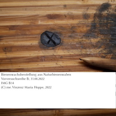 Ein einfacher Schreibversuch mit dem Holzgriffel in der durch Einkneten von Ruß (hier Stearinruß) gewonnenen schwärzlichen Masse aus dem ursprünglich in Vorversuchsreihe B gewonnenen Bienenwachs.